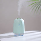 Mint green spray humidifier producing mist