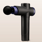 Black handheld massage gun on a warm neutral background